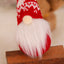 Christmas forest gnome ornament hanging on evergreen tree surrounded by soft bokeh lights