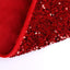 Red sequin Christmas tree skirt spread beneath a decorated holiday tree with festive sparkle