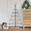 125 cm matte black pine cone Christmas tree with steel frame and pine wood stand in living room setting