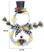 Christmas wreath pendant with warm LED lights glowing softly against dark background