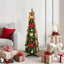 Pre-lit artificial Christmas tree with warm white LED lights standing in a festive room setting