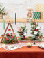 Christmas tree decoration featuring wooden base with artificial flowers and warm glowing lights