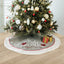Christmas tree skirt with festive gloves pattern draped around a decorated tree in warm lighting