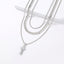 Layered Cuban chain necklace with geometric cross pendant in silver-tone