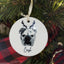 White porcelain pet portrait ornament hanging on Christmas tree branch