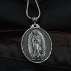 Religious pendant featuring Virgin Mary in black metal design