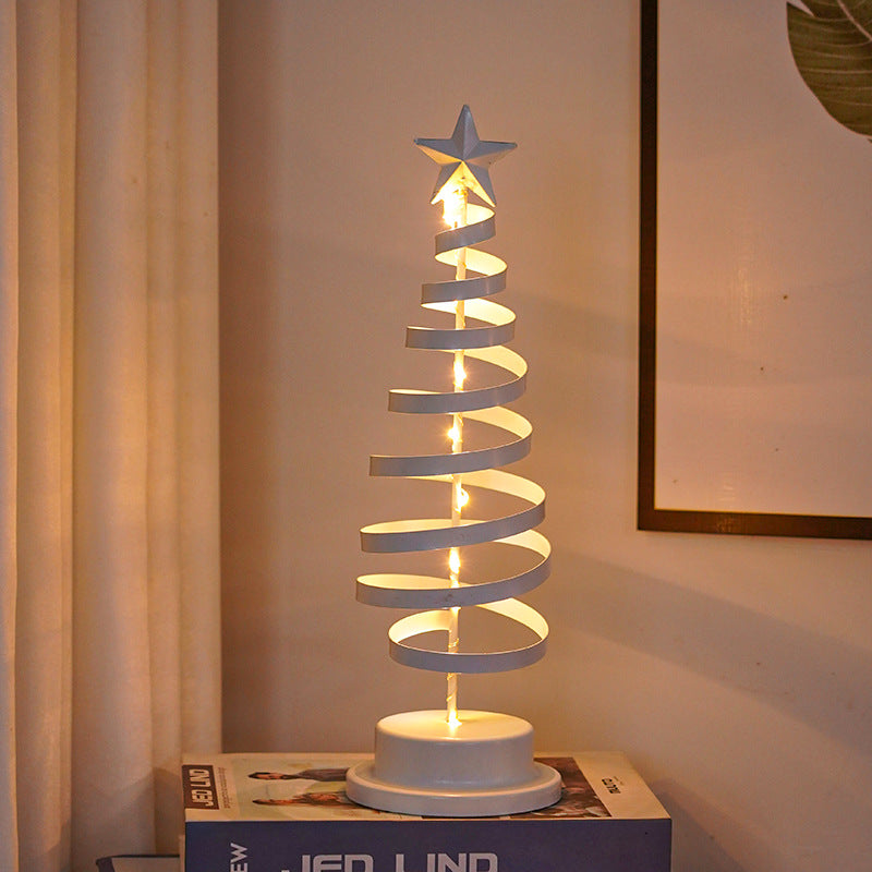 Iron Christmas tree light ornament with spiral design glowing warmly