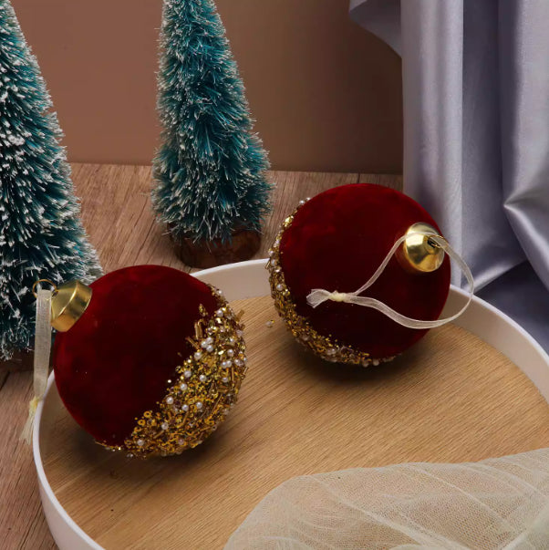 Set of burgundy flocked glass Christmas ornaments displayed on wreath