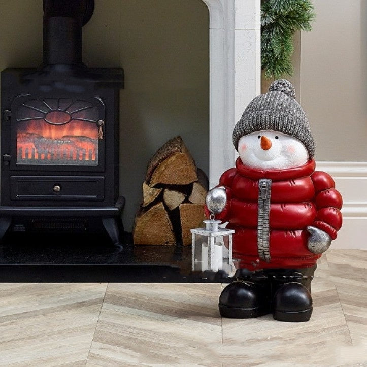 Close-up of resin snowman ornament in cozy red jacket for holiday decorations