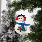 Snowman pendant hanging on Christmas tree branch
