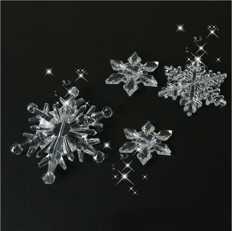 Crystal acrylic Christmas snowflake ornaments arranged decoratively with holiday lights