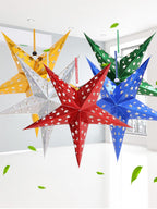Gold five-pointed star Christmas ornament hanging on decorated tree