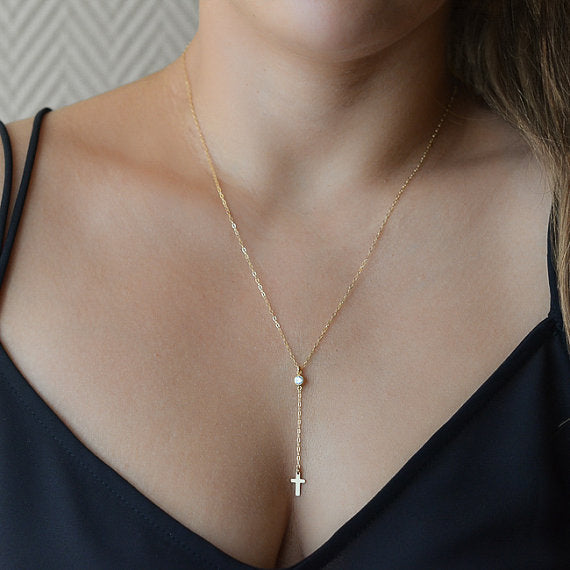 Stacked view of cross pendant necklaces in both color options