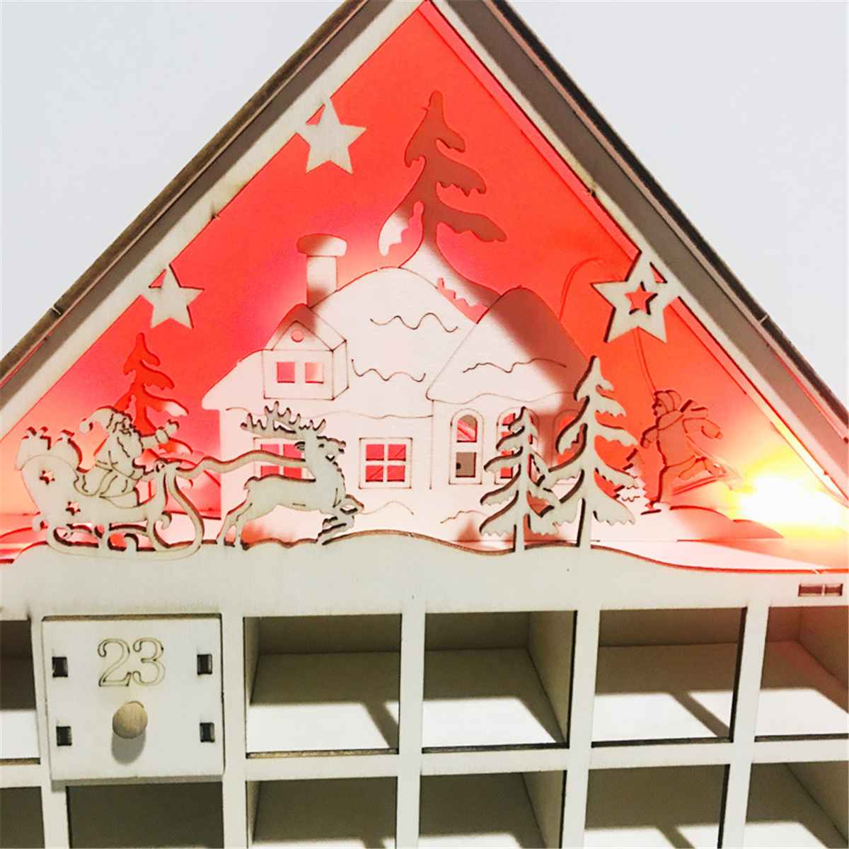 Wooden Christmas countdown calendar displayed beside Bible and candlelight