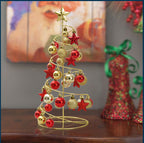 Red gold iron mini Christmas tree on desk with Bible in background