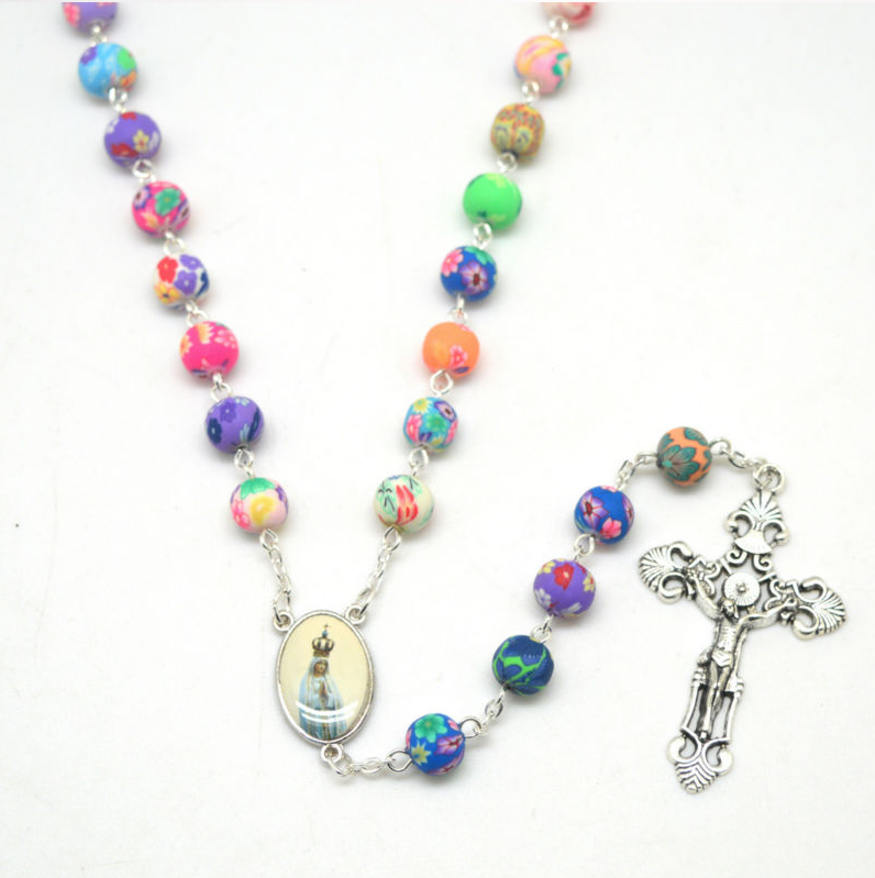 Close-up of ceramic rosary beads with Mary figurine centerpiece