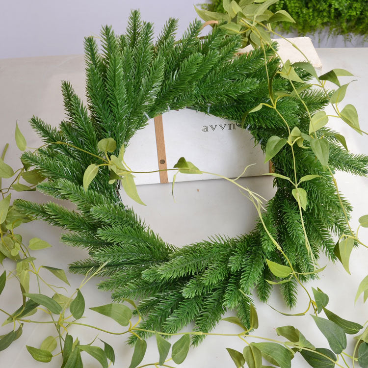 Green evergreen pine decoration picks arranged in a decorative setting with faith-inspired elements