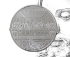 Close-up of Jesus Christ religious medallion detail on gold-tone coin