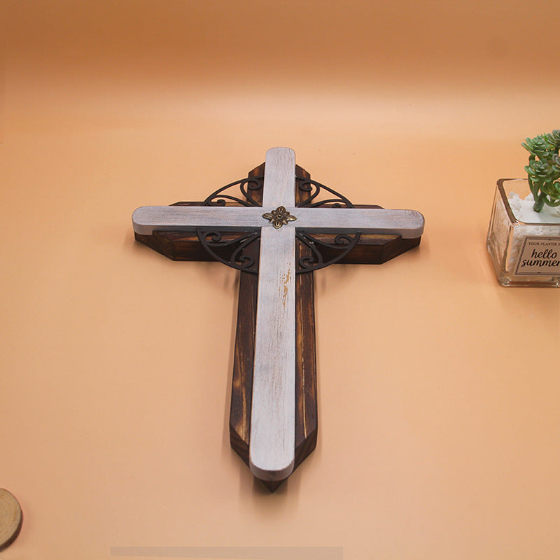 Hand holding the wooden cross pendant demonstrating size and wearability