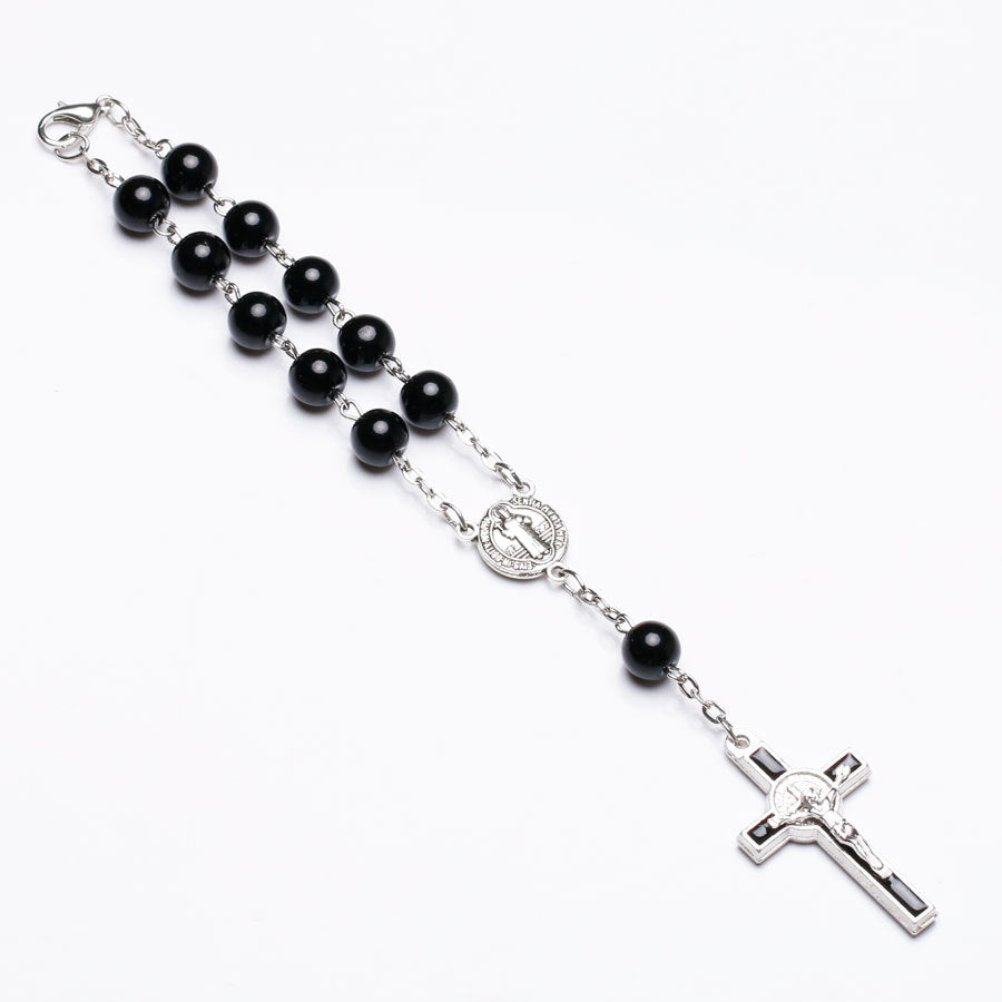 Rosary bracelet with dripping cross connector on neutral background