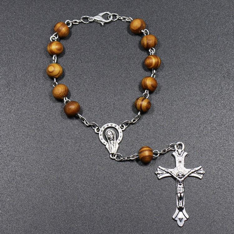 Rosary bracelet showing cross detail and wooden bead texture