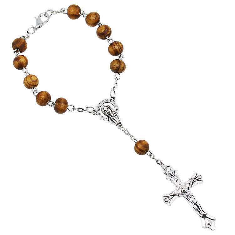 Wooden beads rosary bracelet with cross centerpiece on neutral background