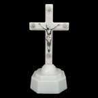 Glowing cross ornament with warm light against dark background
