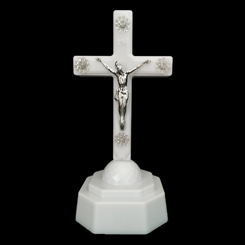 Glowing cross ornament with warm light against dark background