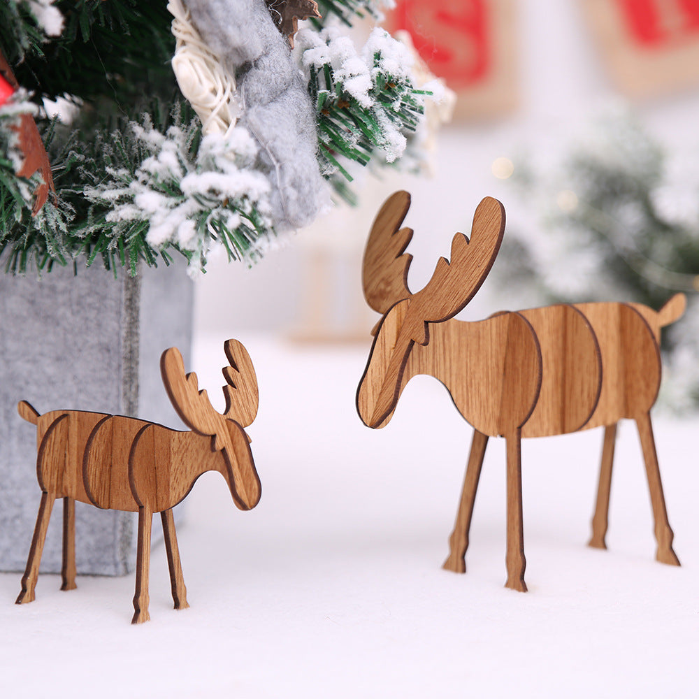 Set of wooden elk Christmas ornaments displayed among evergreen branches and pinecones