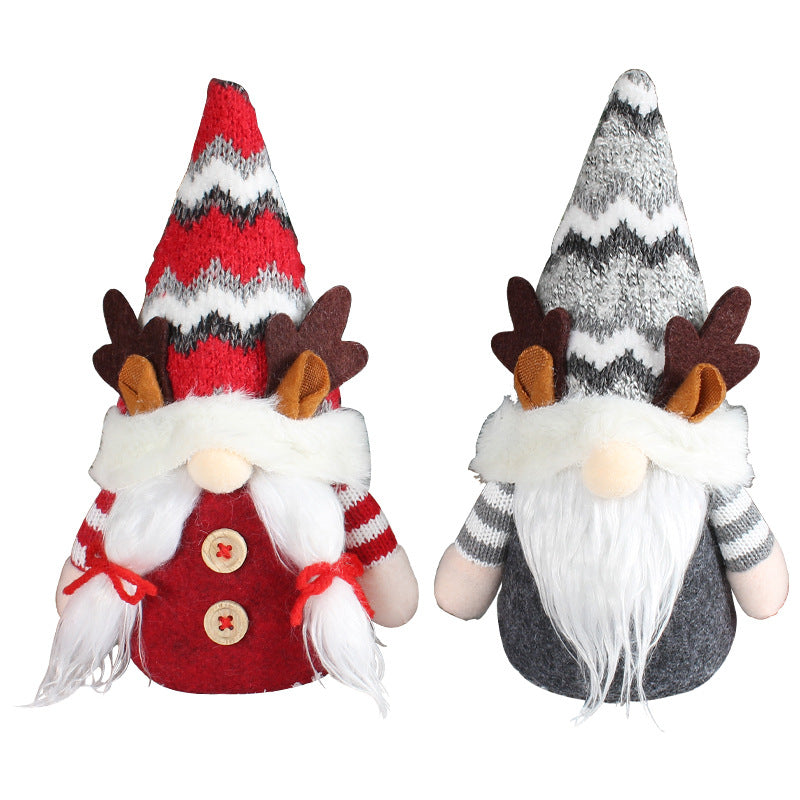 Festive deer doll featuring pointed hat and antlers nestled among holiday greenery