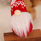Christmas forest gnome ornament hanging on evergreen tree surrounded by soft bokeh lights