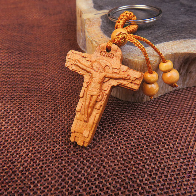 Close-up of embossed relief carving detail on natural wood keychain