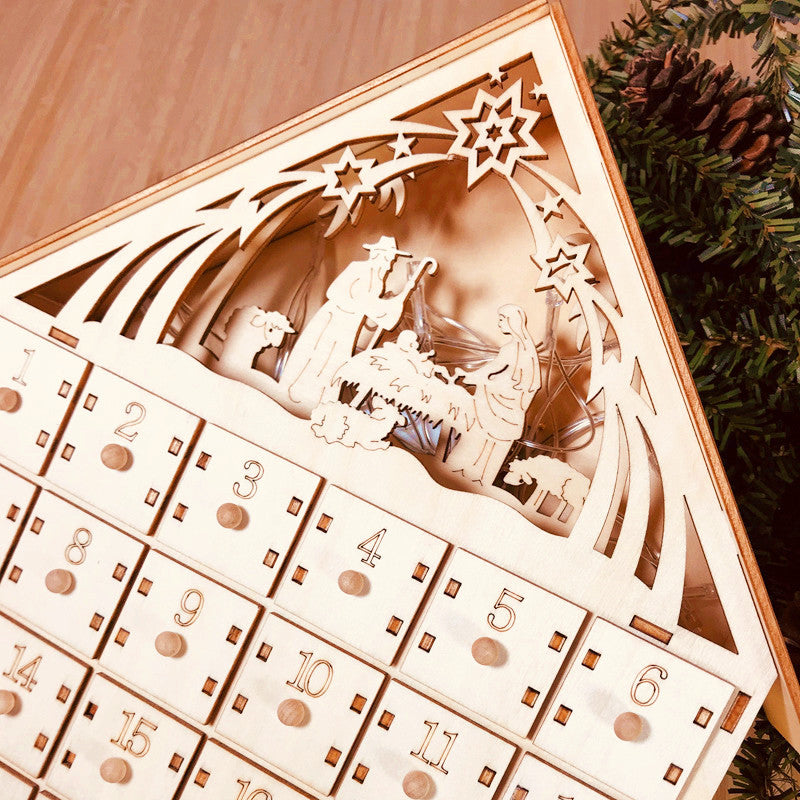 DIY wooden Christmas advent calendar with carved compartments arranged on festive table