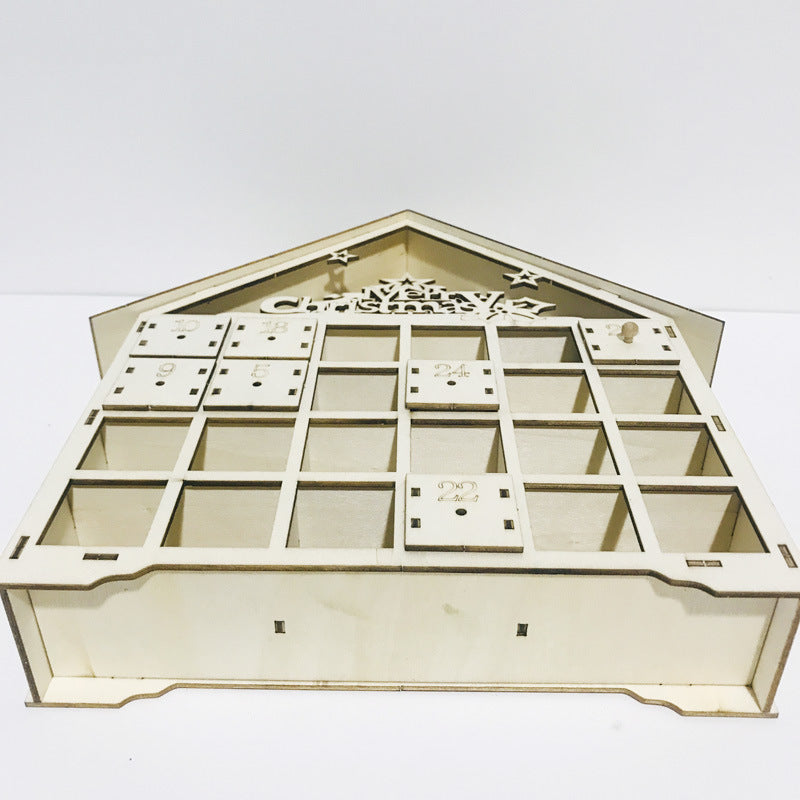 Wooden Christmas calendar cabinet with Christmas greenery and candles nearby