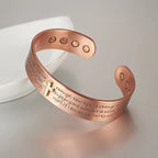 Red copper cross bracelet with magnetic elements displayed on a light background