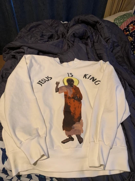 Woman wearing cozy Jesus is King hoodie in everyday setting