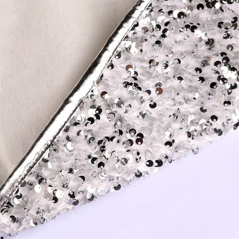 Silver white sequin Christmas tree skirt draped around holiday tree in festive living room setting
