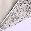 Silver white sequin Christmas tree skirt draped around holiday tree in festive living room setting