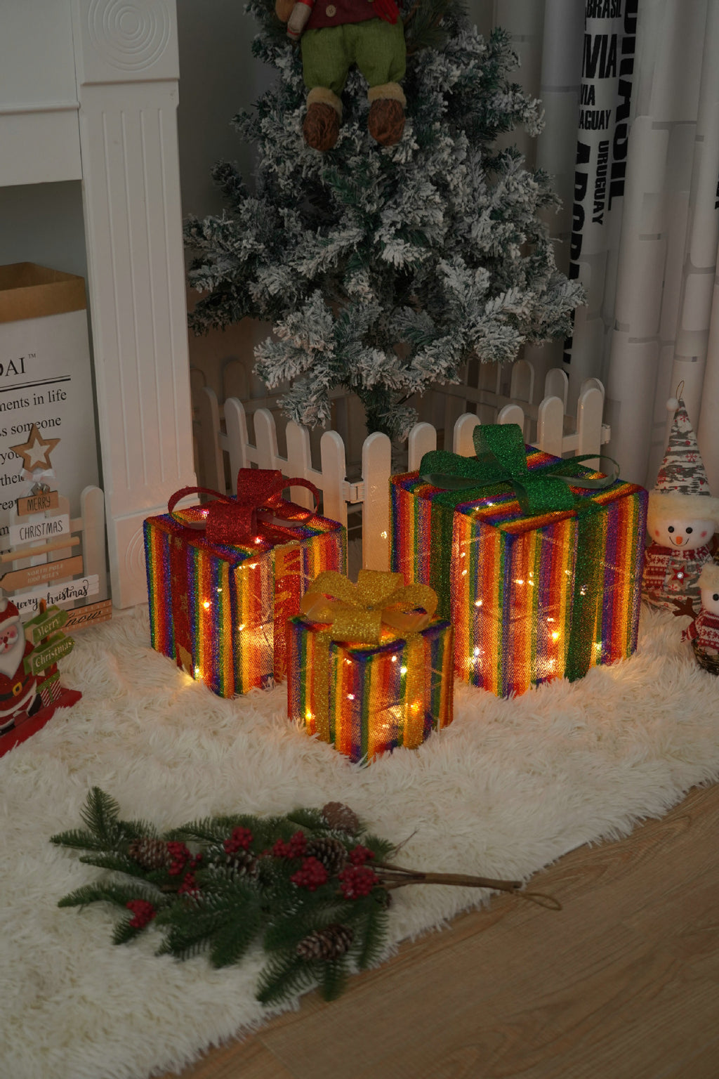 Set of three Christmas gift box lights displayed on festive surface with remote control nearby