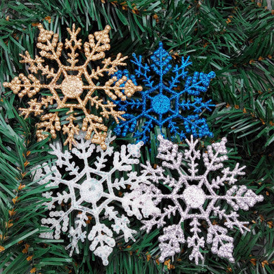 Snowflake Christmas hanger catching light on green branches