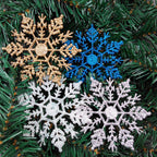 Snowflake Christmas hanger catching light on green branches