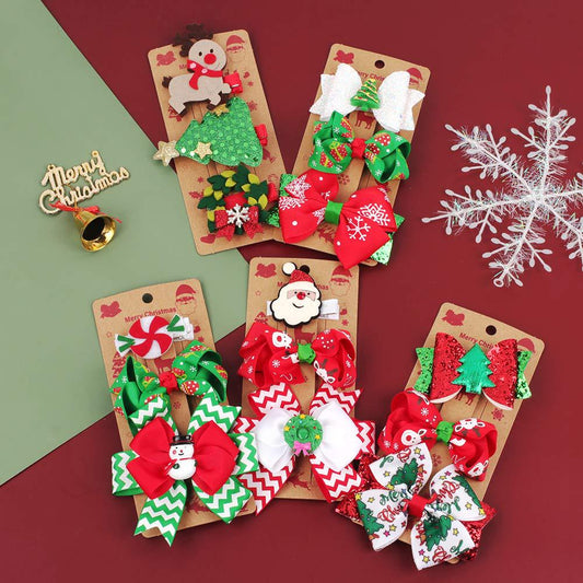 Set of three red and green Christmas bow barrettes for girls styled on a surface