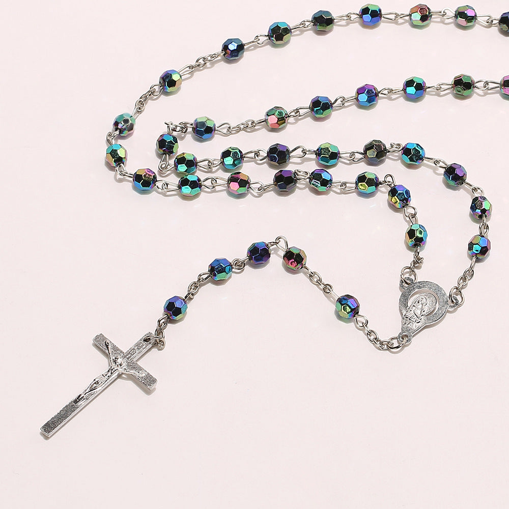 Close-up of the alloy crucifix pendant on a colorful horn bead rosary chain