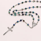 Close-up of the alloy crucifix pendant on a colorful horn bead rosary chain
