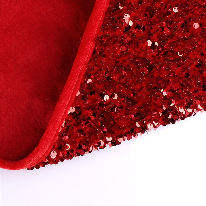 Red sequin Christmas tree skirt spread beneath a decorated holiday tree with festive sparkle