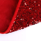 Red sequin Christmas tree skirt spread beneath a decorated holiday tree with festive sparkle