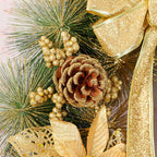 Pine needle wreath Christmas ornament surrounded by evergreen branches and ribbon
