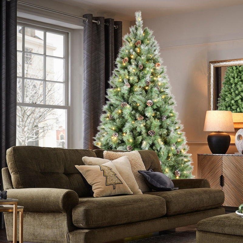 Close-up of PVC Christmas tree branches with realistic pine cones and soft LED illumination
