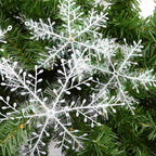 Snowflake ornaments arranged among evergreen branches for Christmas display
