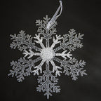 Christmas tree decorated with various ornaments including transparent snowflake pendant